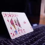 Playing cards balanced on a laptop.