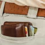 A stuffed wallet with credit cards in a pair of khaki pants.