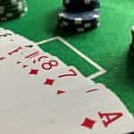 A spread-out deck of cards next to poker chips.