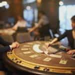 A blackjack casino worker deals cards.