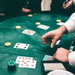 A croupier dealing cards in a game of poker at a casino.