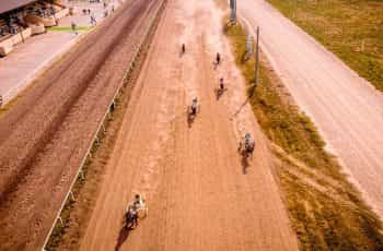 A group of horse-cart riders on a track.