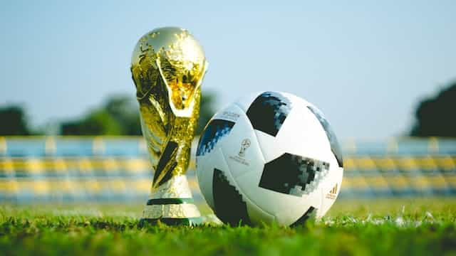 A bright green soccer ball is on a soccer field.