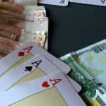 Chips, cash and aces on a poker table.